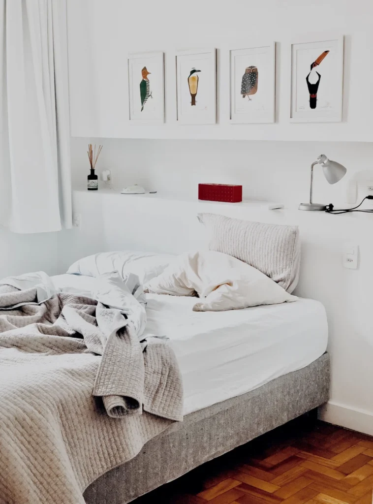 A bed with white sheets and pillows on it.