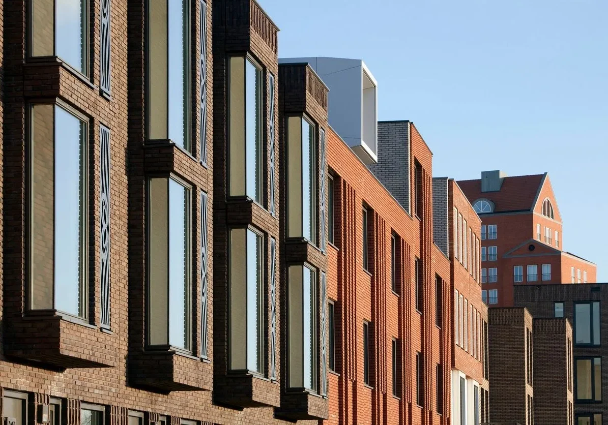 A row of brick buildings with windows on the side.