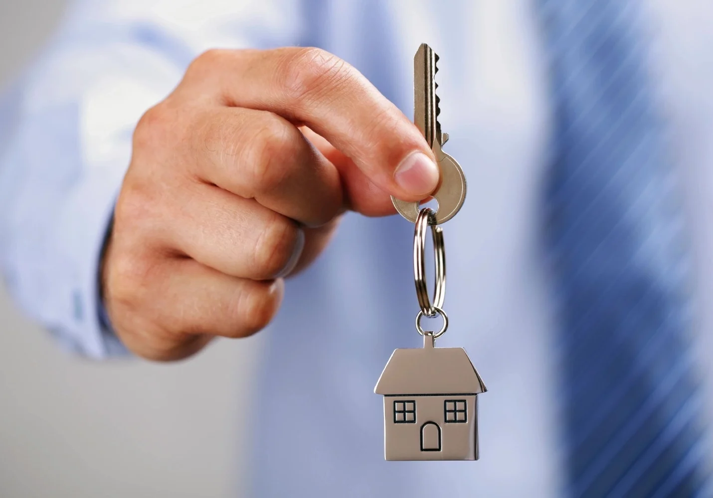 A person holding keys to a house